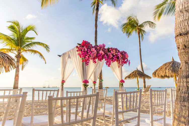 Un arco de boda instalado en la playa durante la puesta de sol.